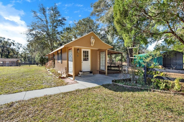 view of front of house with a front yard and an outdoor structure