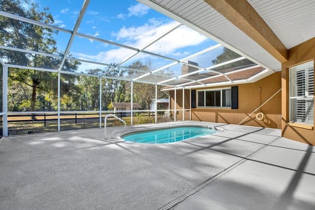 view of swimming pool featuring a lanai and a patio area