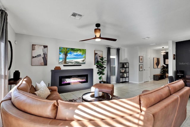 tiled living room featuring ceiling fan with notable chandelier