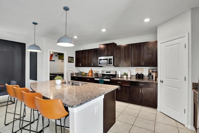 kitchen with pendant lighting, sink, an island with sink, and appliances with stainless steel finishes