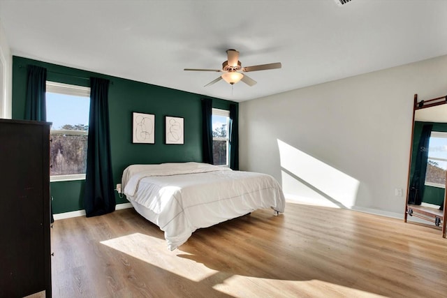 bedroom with light hardwood / wood-style flooring and ceiling fan