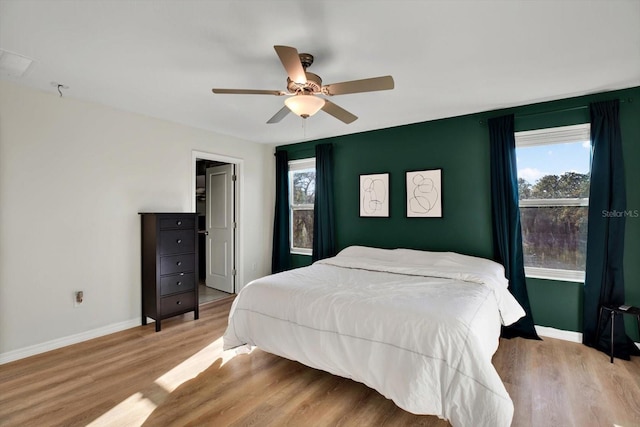 bedroom featuring multiple windows, ceiling fan, and light hardwood / wood-style floors