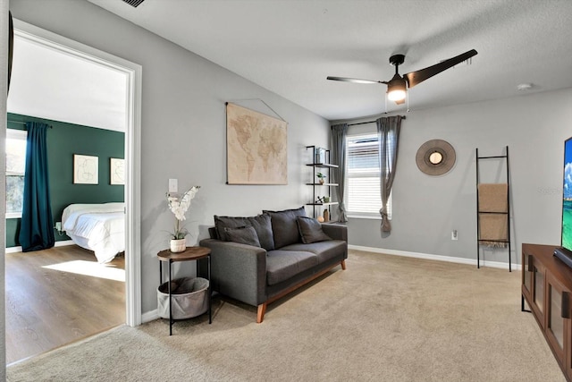 carpeted living room with ceiling fan