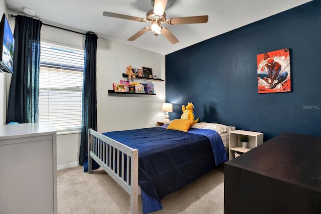 bedroom featuring ceiling fan, light carpet, and multiple windows