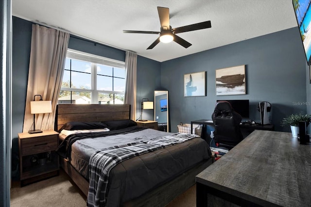 carpeted bedroom featuring ceiling fan and a textured ceiling