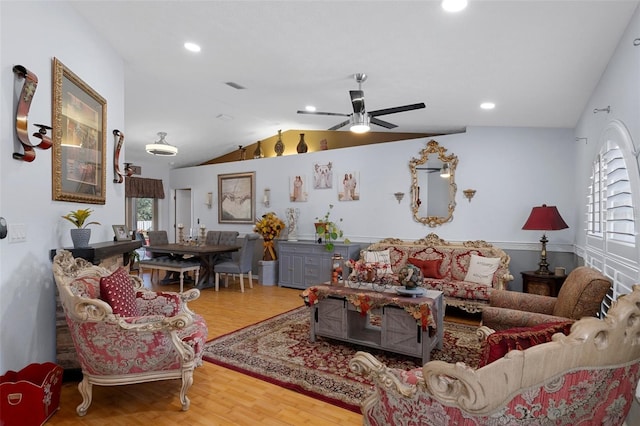 living room featuring wood-type flooring, vaulted ceiling, and ceiling fan