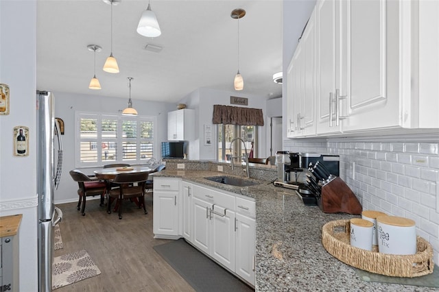 kitchen featuring a healthy amount of sunlight, white cabinetry, sink, and hanging light fixtures