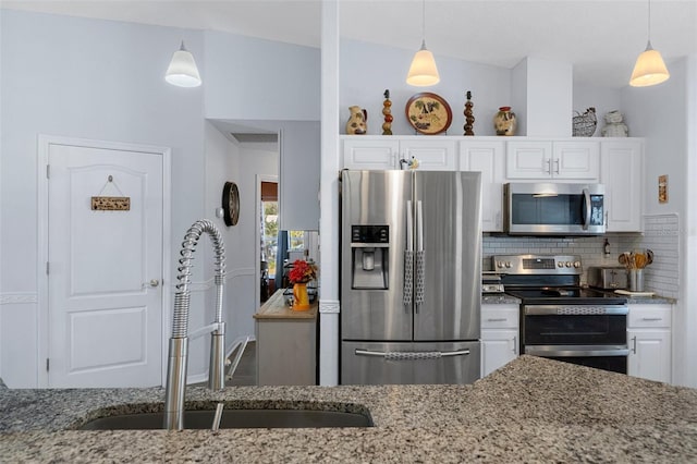 kitchen featuring light stone countertops, sink, stainless steel appliances, pendant lighting, and white cabinets