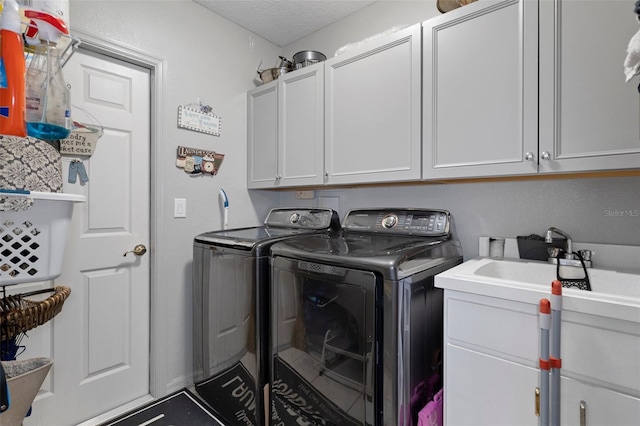 clothes washing area featuring cabinets, independent washer and dryer, and a textured ceiling