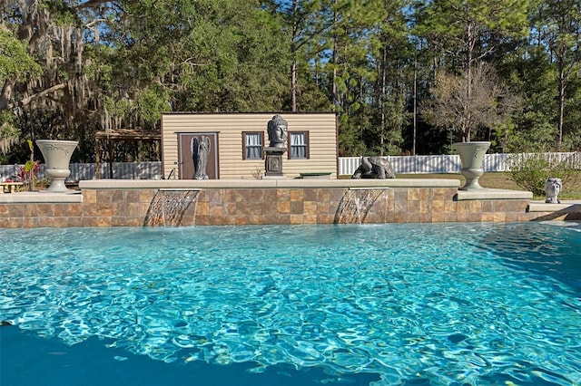 view of pool featuring pool water feature and an outbuilding