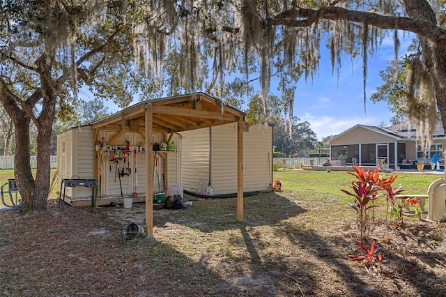 view of outdoor structure with a lawn and a sunroom