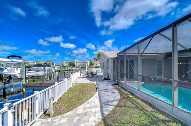 exterior space featuring a boat dock, a water view, and glass enclosure