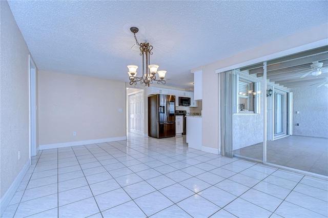 interior space with light tile patterned flooring, a textured ceiling, and an inviting chandelier