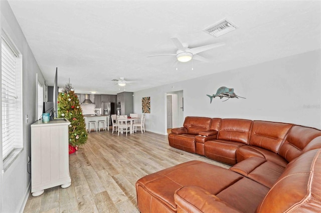 living room with light hardwood / wood-style floors and ceiling fan