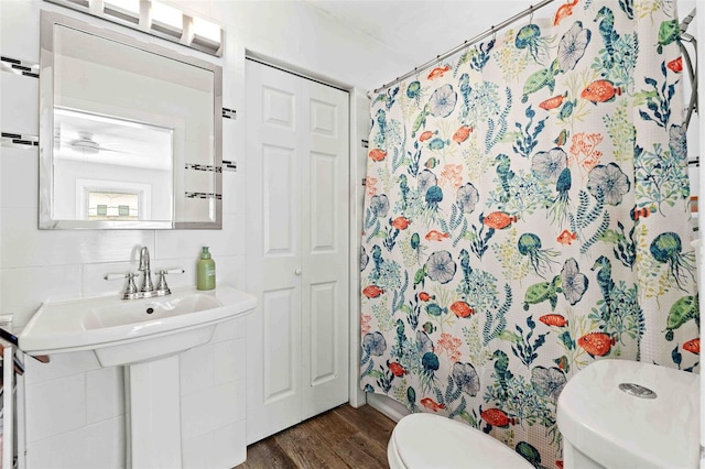 bathroom featuring tasteful backsplash, hardwood / wood-style floors, a shower with shower curtain, and toilet