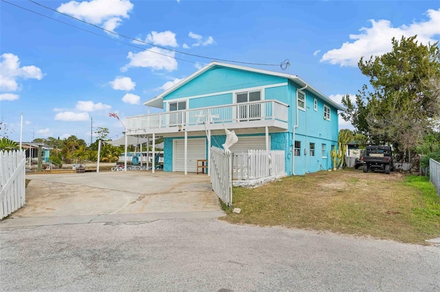 view of front of house with a balcony, a garage, and a front lawn