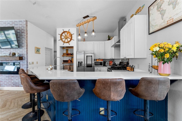 kitchen with a breakfast bar area, light parquet floors, and stainless steel appliances