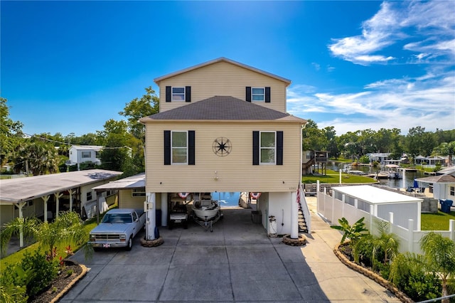 view of front of house with a carport and a water view