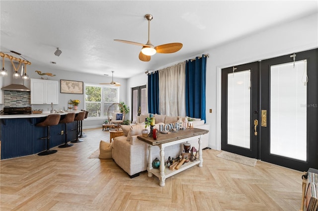 living room featuring ceiling fan, french doors, and light parquet flooring