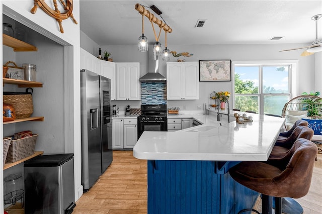 kitchen with a kitchen bar, white cabinets, black range oven, and stainless steel refrigerator with ice dispenser