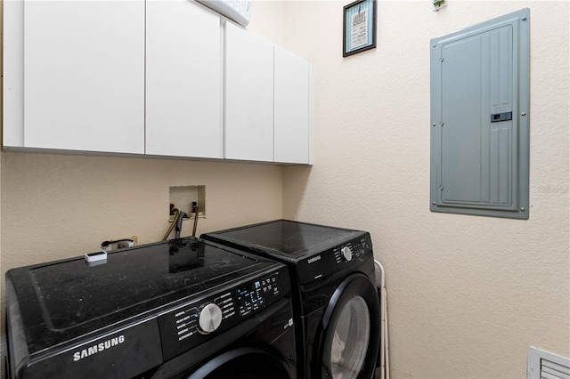 laundry area featuring cabinets, electric panel, and washer and clothes dryer