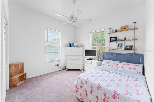 carpeted bedroom with ceiling fan and multiple windows