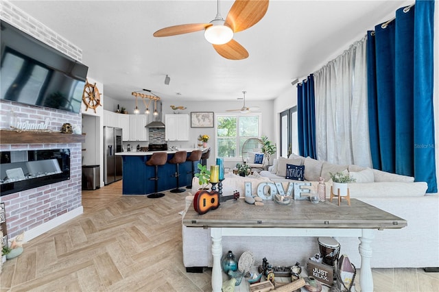 living room with light parquet floors and a brick fireplace