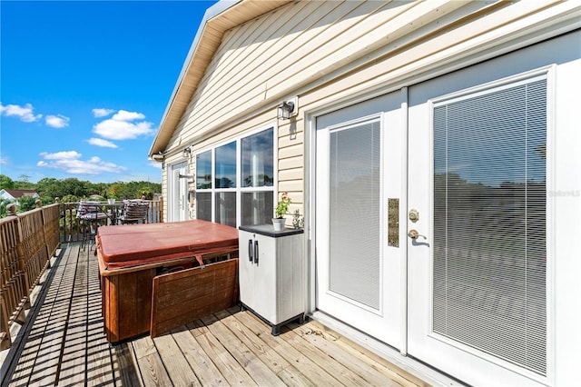 wooden deck with french doors and a hot tub