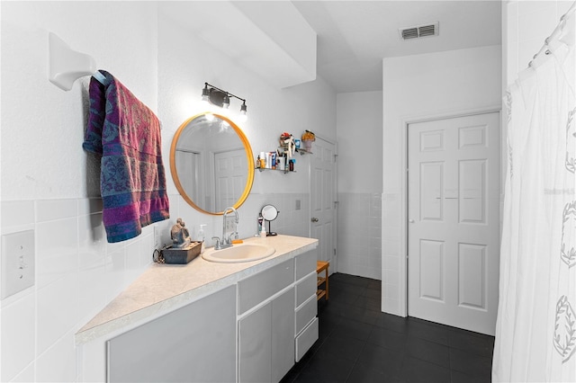 bathroom featuring vanity and tile walls