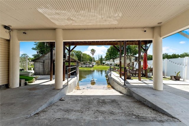 view of patio featuring a water view and a storage shed