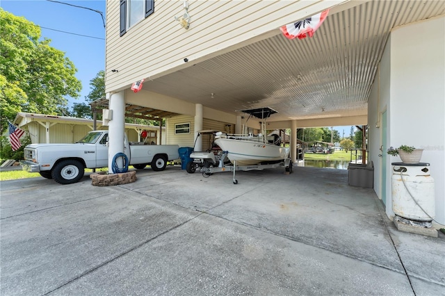 view of parking featuring a carport and a water view