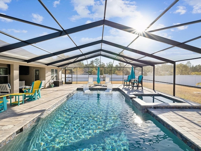 view of swimming pool with an in ground hot tub, a patio, pool water feature, and a lanai