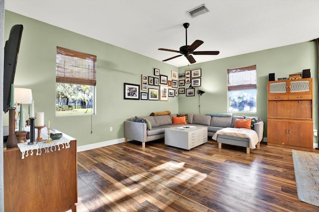 living room featuring ceiling fan and dark wood-type flooring