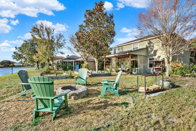 view of yard featuring a water view and an outdoor fire pit