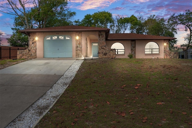 view of front of property featuring a garage and a lawn