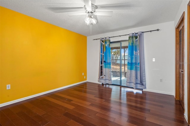 spare room with ceiling fan, dark wood-type flooring, and a textured ceiling