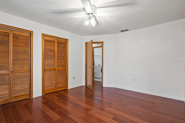 unfurnished bedroom featuring a textured ceiling, ceiling fan, dark wood-type flooring, and two closets