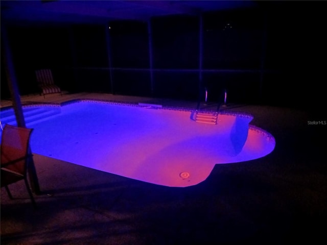 pool at night with a patio area