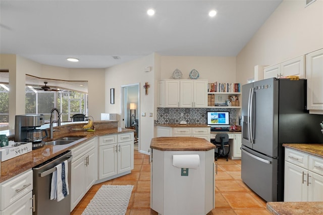 kitchen featuring white cabinets, sink, light tile patterned floors, a kitchen island, and stainless steel appliances