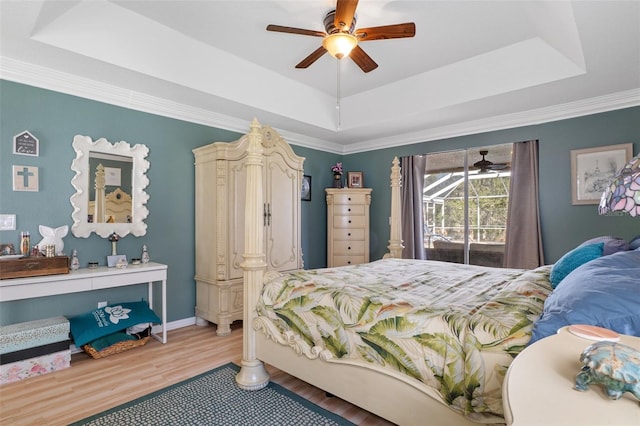 bedroom featuring access to exterior, ceiling fan, a raised ceiling, and hardwood / wood-style floors