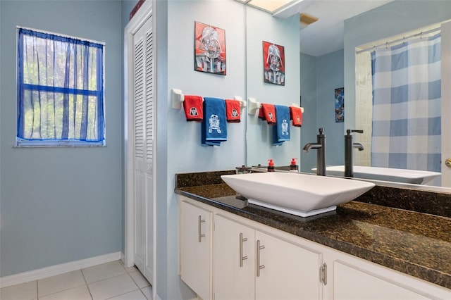 bathroom with tile patterned flooring, vanity, and walk in shower