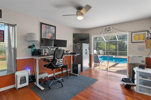 office featuring wood-type flooring, plenty of natural light, and ceiling fan