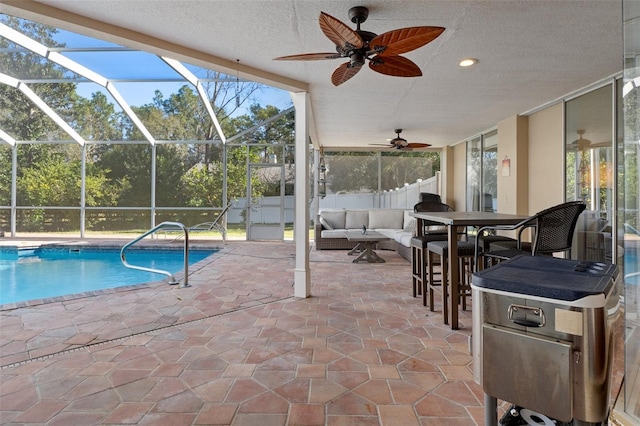 view of swimming pool featuring a lanai, ceiling fan, a patio, and an outdoor living space