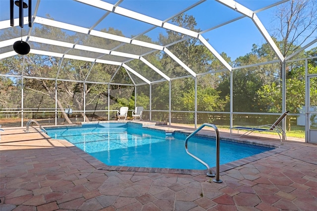 view of swimming pool featuring a patio and a lanai