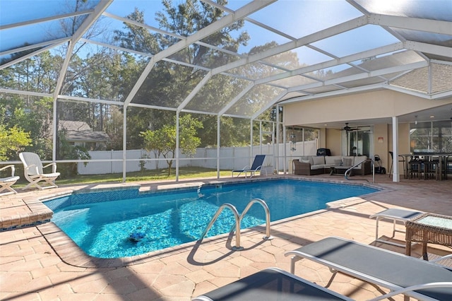 view of pool with outdoor lounge area, a lanai, ceiling fan, and a patio area