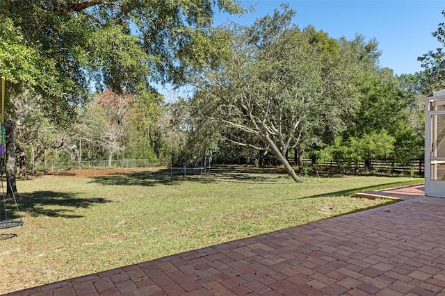 view of yard featuring a patio and a trampoline