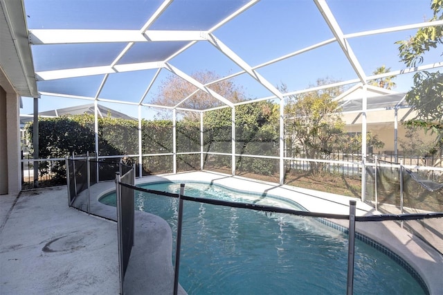 view of pool with glass enclosure and a patio