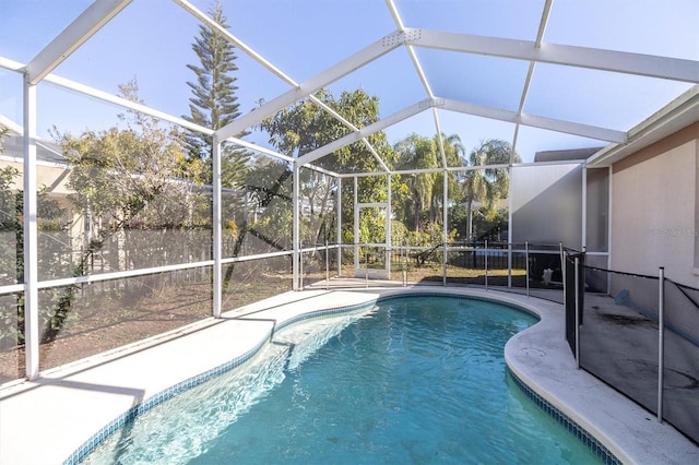 view of swimming pool featuring glass enclosure and a patio