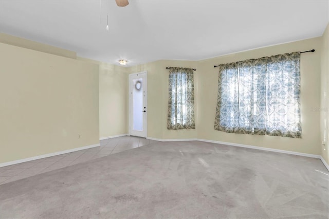 carpeted spare room featuring ceiling fan