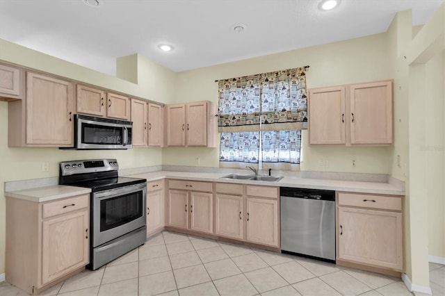 kitchen with light brown cabinetry, sink, light tile patterned floors, and stainless steel appliances